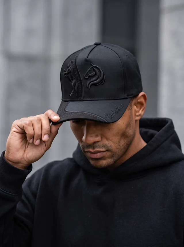 Gorra con relieve negro, mostrada en modelo. Fotografía ORX-024.